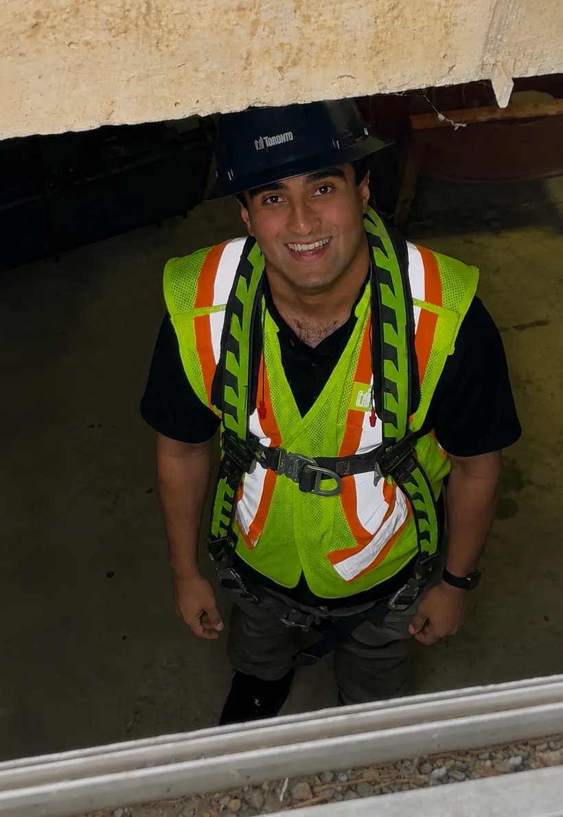 Vivaan in safety harness and high-visibility vest inside a Toronto Water underground chamber